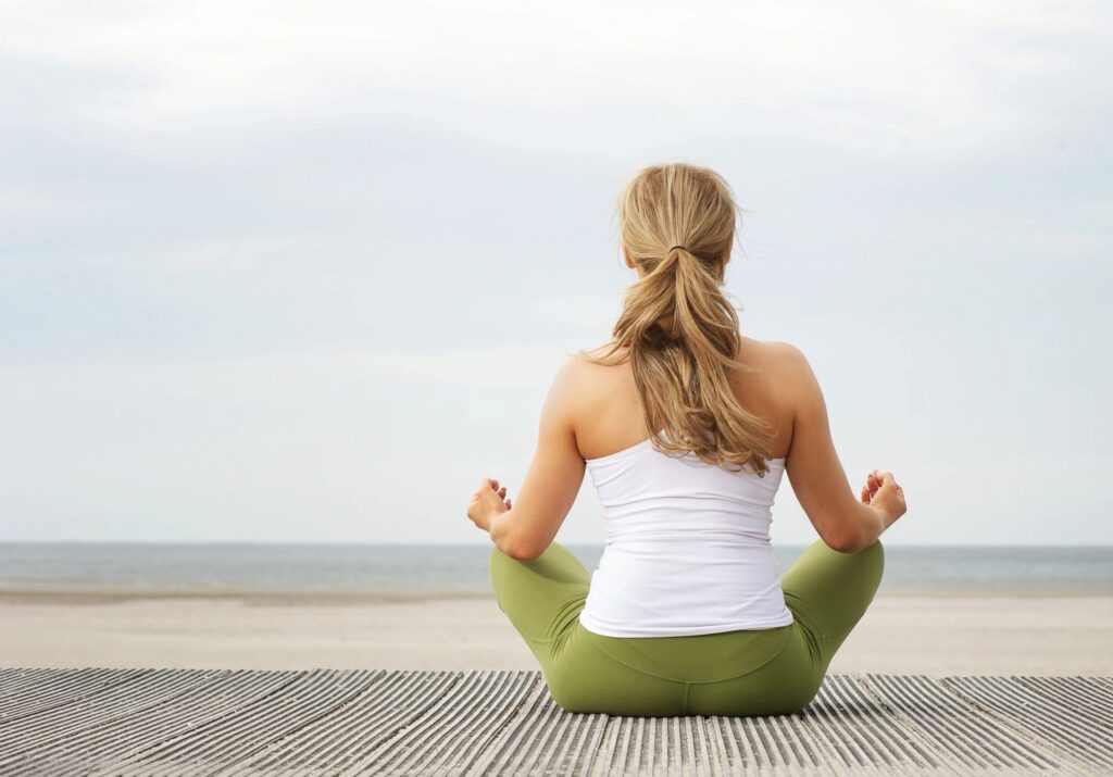 women sitting beachfront relaxation meditation